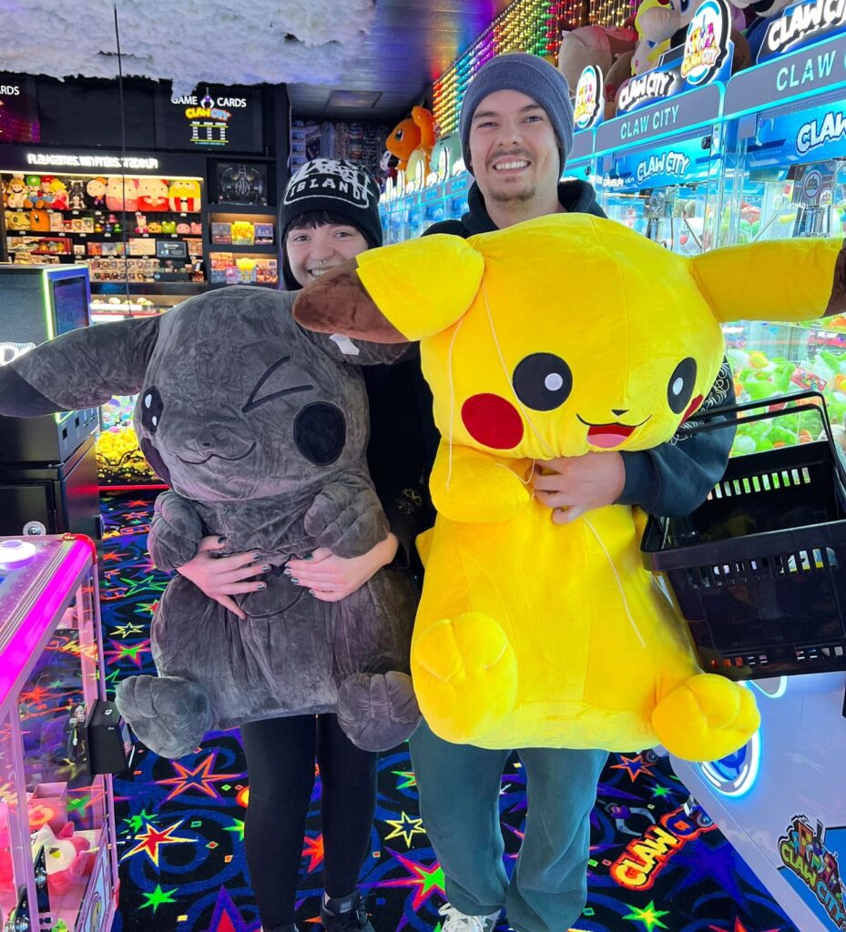 Two persons holding their giant plushies