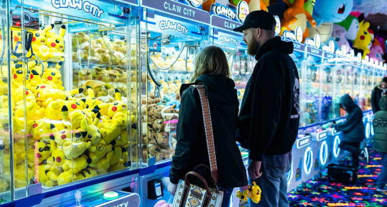 A couple looking at a Claw Machine